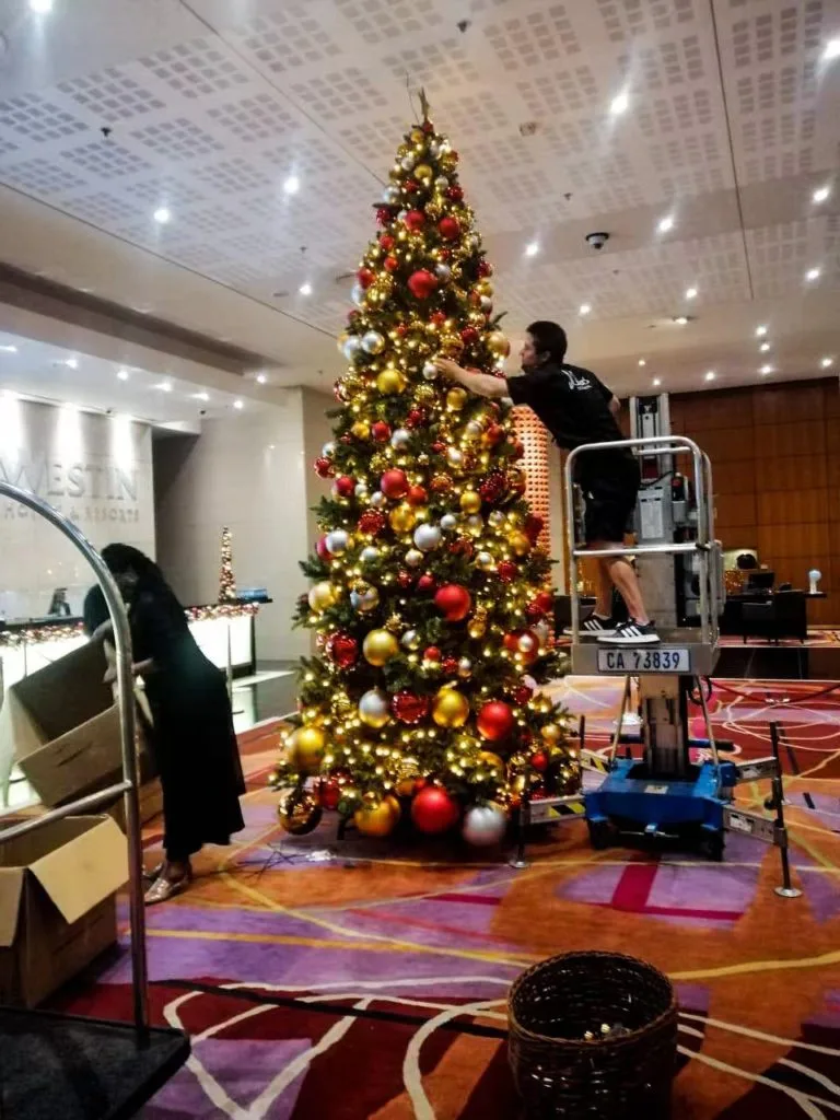 Elegant garland with red and gold baubles displayed in a hotel interior, showcasing luxury Christmas decor and customised festive designs.